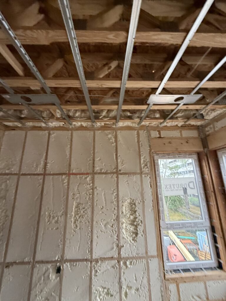 Strapped ceiling grid above foamed walls next to a window - HERS rating in Dudley, MA