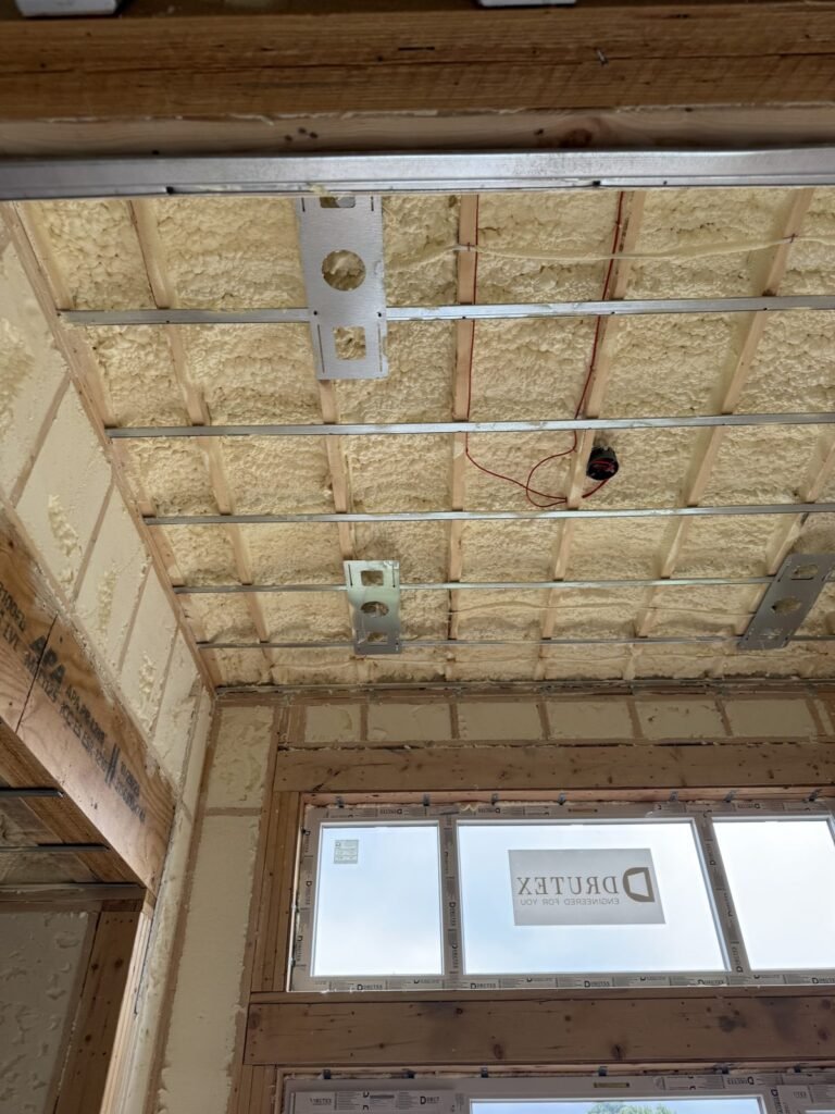 Spray-foamed ceiling and walls above a row of windows - HERS rating in Watertown, MA