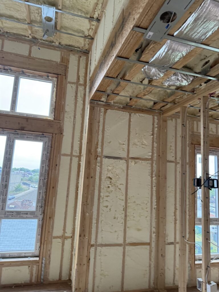 Framed window wall with foam and ceiling strapping ready for drywall - HERS rating in Fairhaven, MA