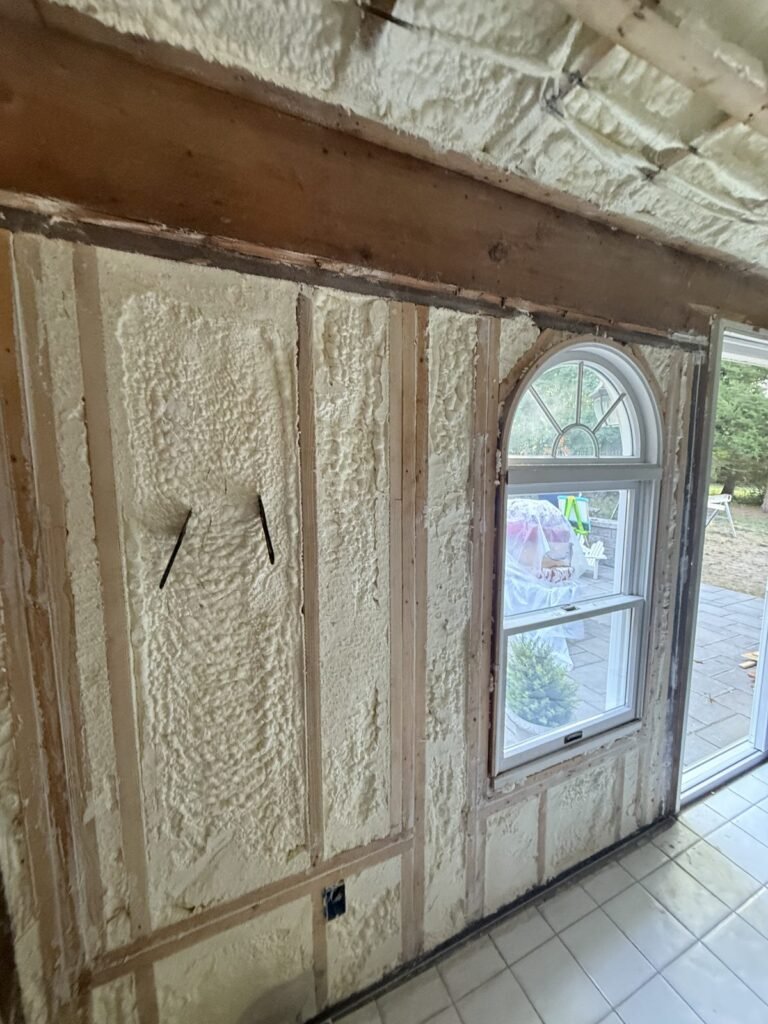 Arched window framed by foam-filled wall bays in an older home - spray foam insulation in Sharon, MA