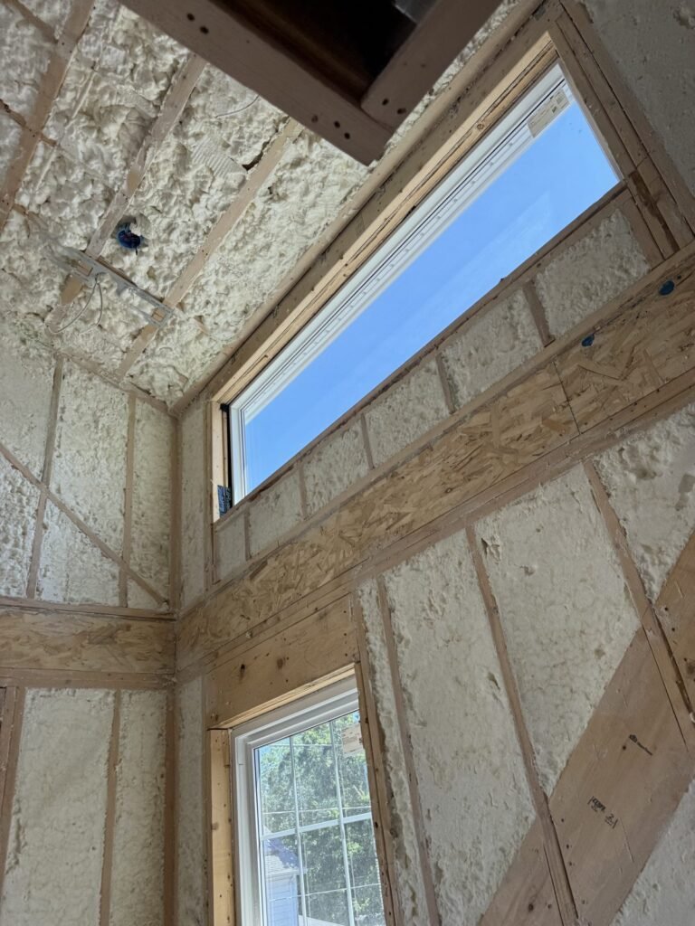 Spray foam sealing around a basement window in a concrete block wall - HERS rating in Northfield, MA