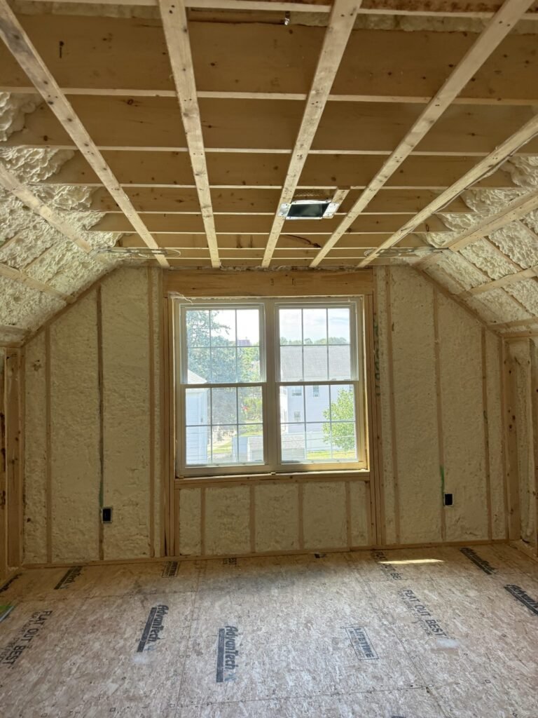 Gable-end room with foamed walls and a strapped ceiling around a centered window - HERS rating in Gardner, MA