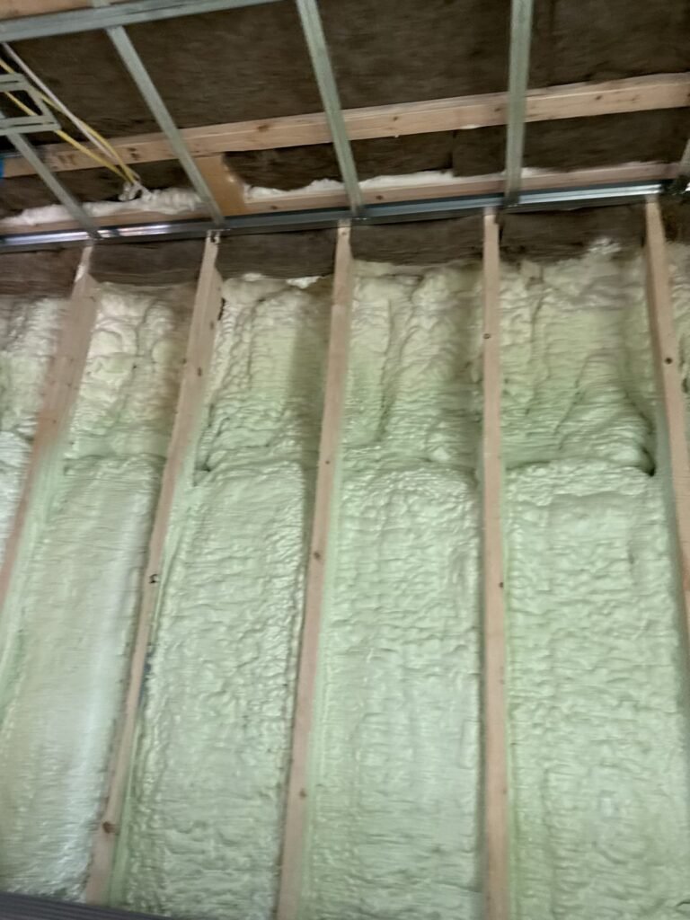 Green-tinted spray foam filling wall cavities between studs - HERS rating in North Reading, MA