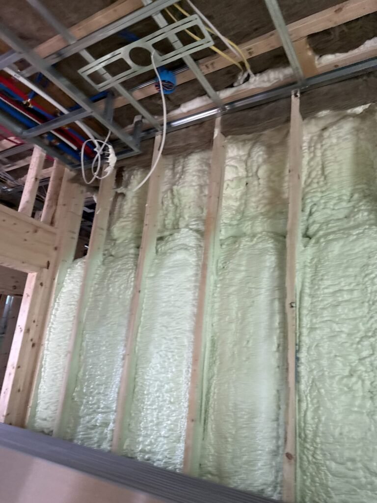 Green-tinted spray foam in tall wall bays beneath ceiling wiring - HERS rating in Charlemont, MA