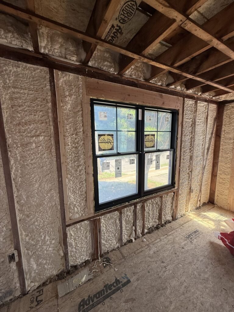 Spray-foamed walls framing a black double window - HERS rating in Franklin, MA