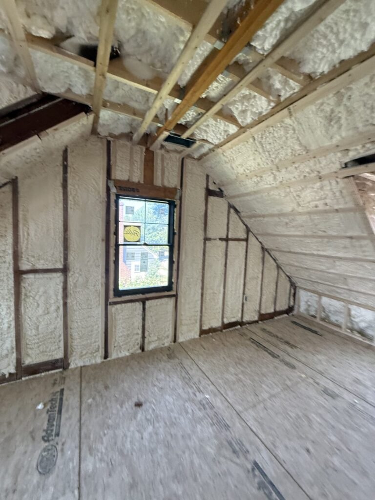 Attic bedroom with spray-foamed sloped ceilings around a gable window - HERS rating in Nahant, MA