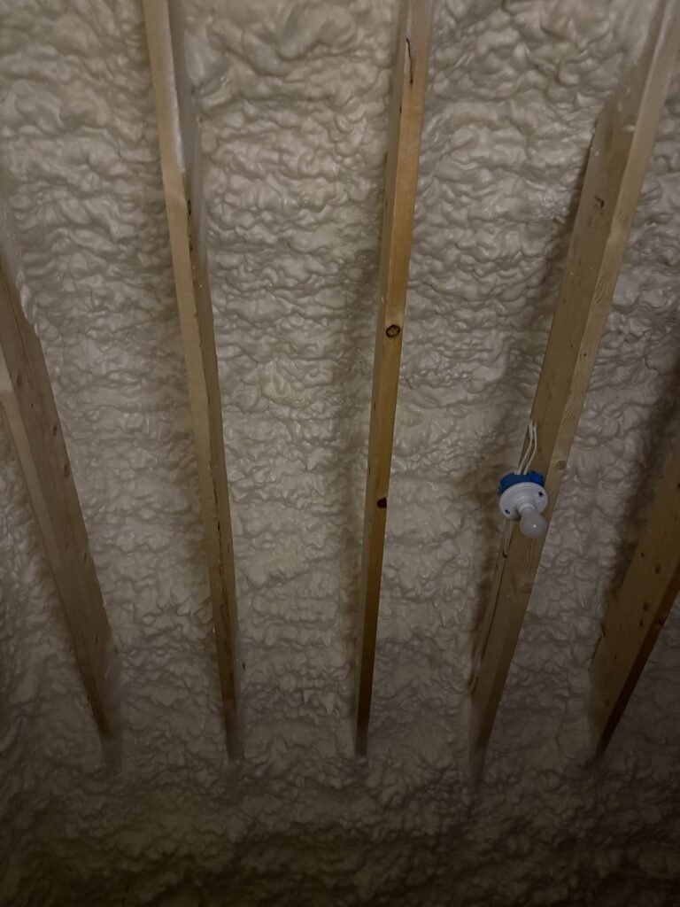 Spray foam sealing roof rafters with a ceiling box in place - spray foam insulation in Holbrook, MA