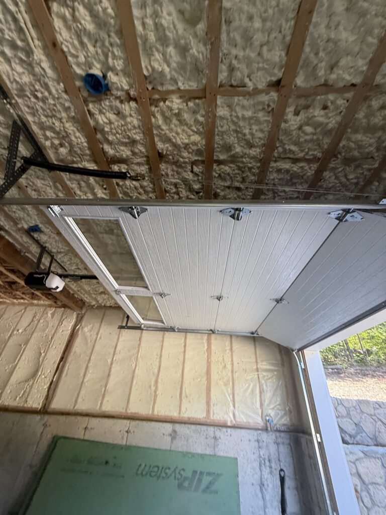Spray-foamed garage ceiling above an open overhead door - spray foam insulation in Worcester, MA