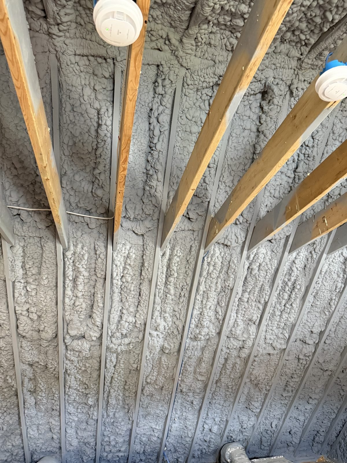 Spray foam insulation between roof rafters for an air-sealed, conditioned attic in Massachusetts