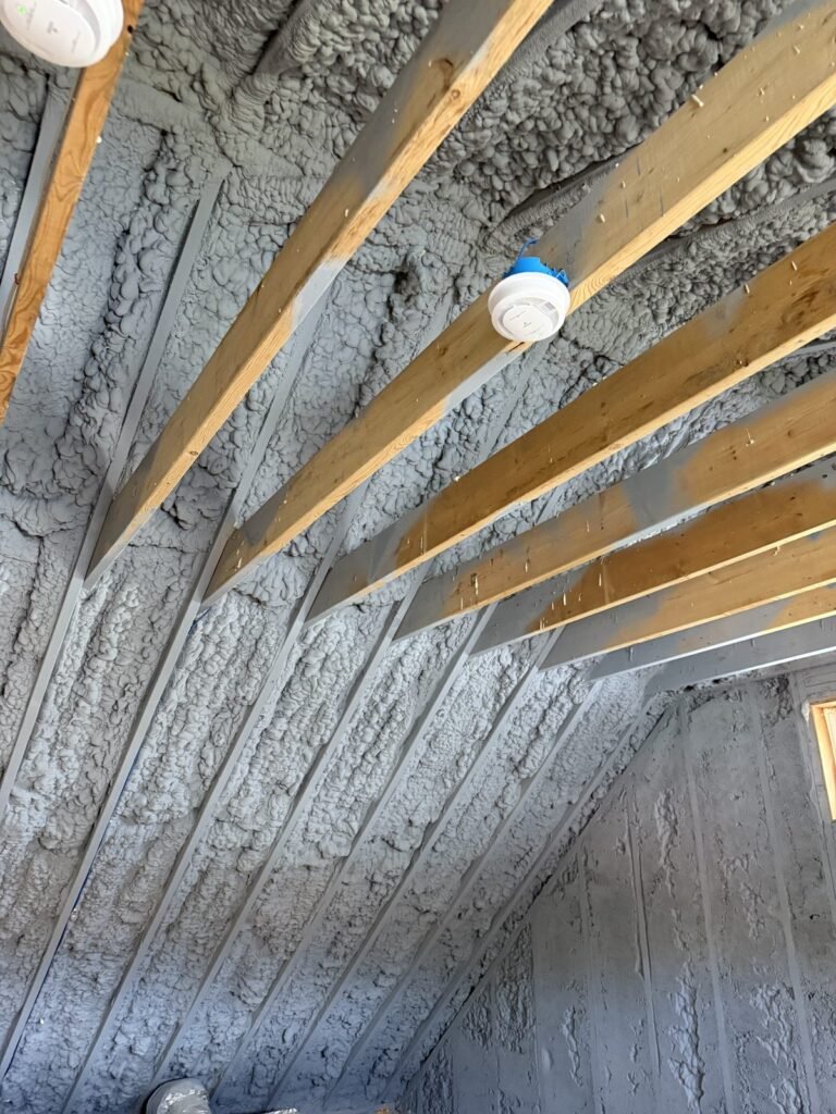 Spray-foamed roof slope between rafters over a top-floor room - HERS rating in Medford, MA