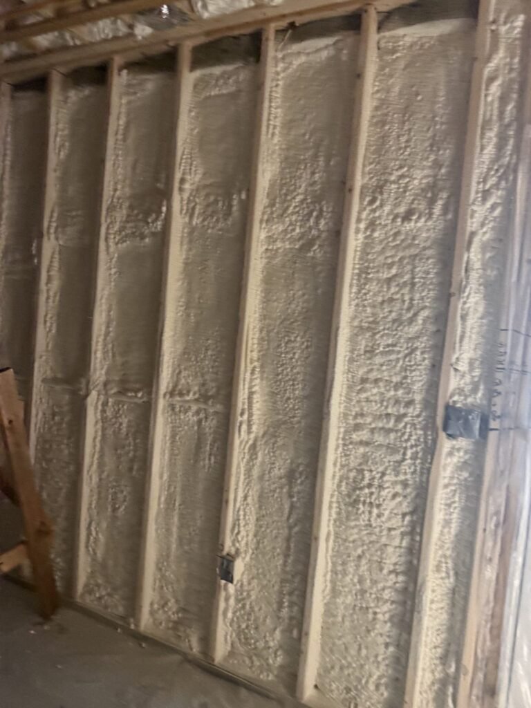 Close view of spray foam filling wall stud cavities - HERS rating in Dighton, MA