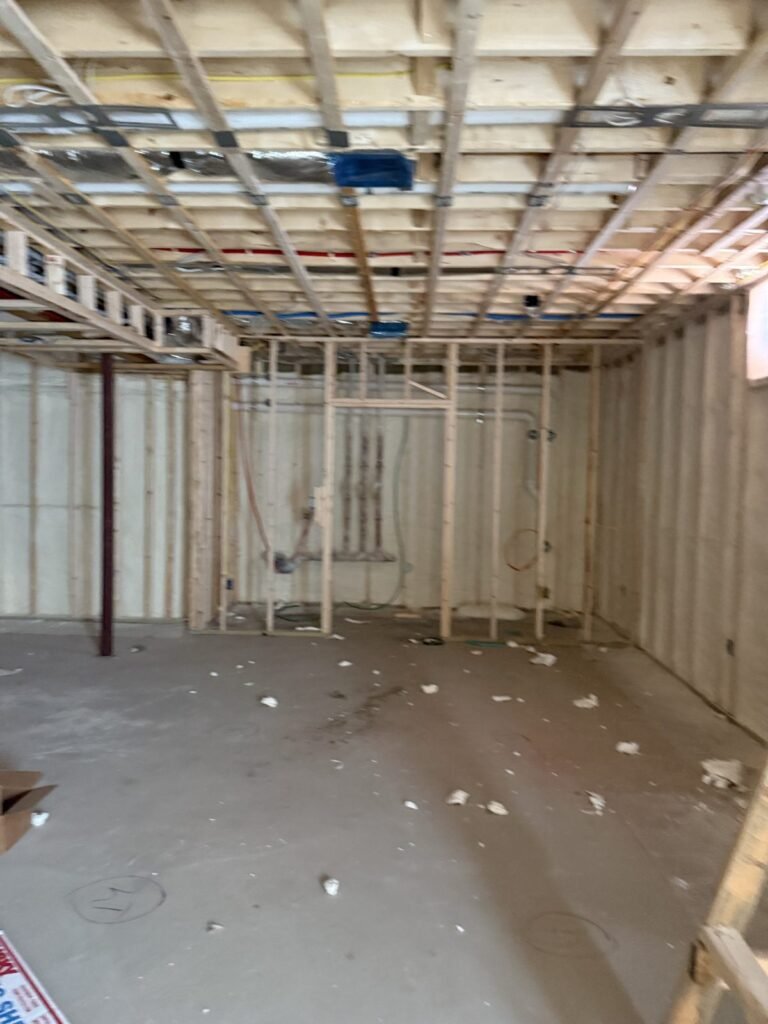 Open lower level with a foamed ceiling and new partition framing - spray foam insulation in Dunstable, MA