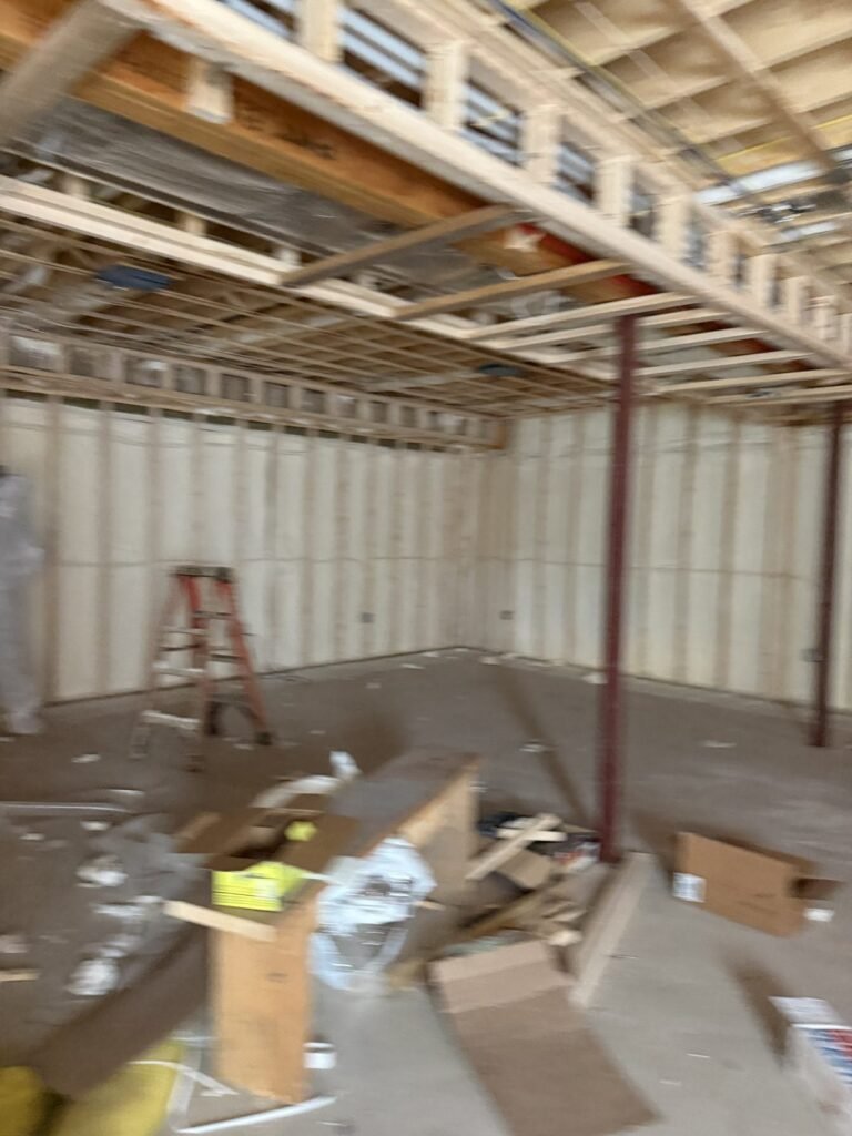Spray-foamed walls with a stepladder and building materials in a framed room - HERS rating in Middleton, MA